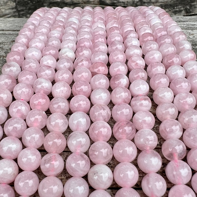 Madagascar rose quartz beads strands on top of a trunk