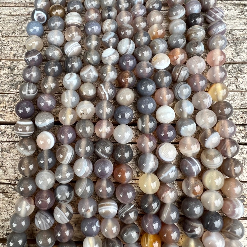 Botswana agate stone beads strands laid on a trunk pictured from front