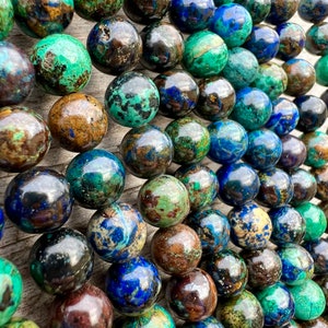 Azurite stone beads strands laid on bright wood surface in outdoor and pictured under natural day light.