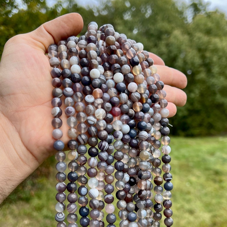 8mm Botswana agate stone beads strands held in hand in outdoor under natural light
