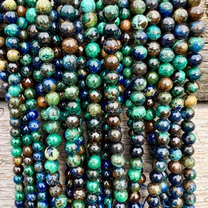 Azurite stone beads strands laid on bright wood surface in outdoor and pictured under natural day light.