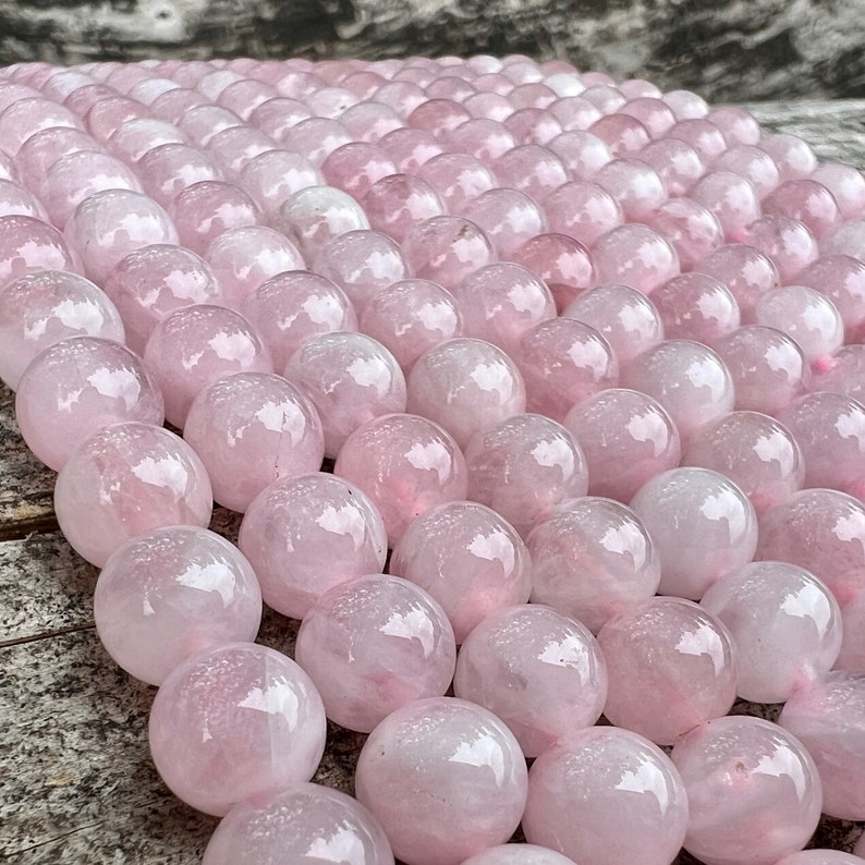 Madagascar rose quartz beads strands on top of a trunk