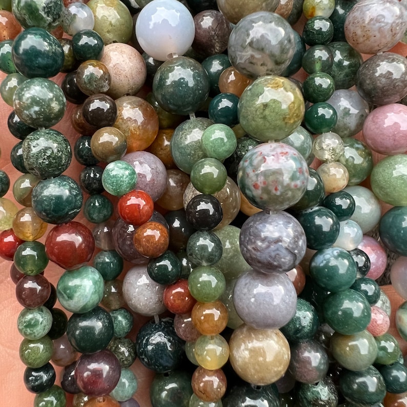 Indian agate stone beads strand stacked and held in hand from a close look