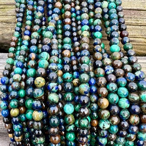 Azurite stone beads strands laid on bright wood surface in outdoor and pictured under natural day light.