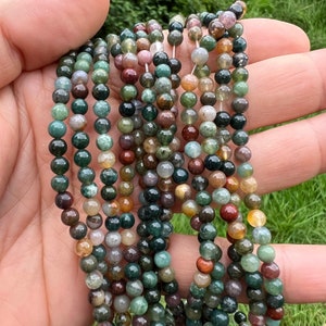 6mm Indian agate stone beads strand stacked and held in hand from a close look