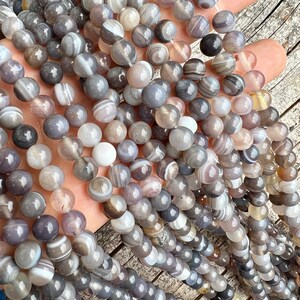 Botswana agate stone beads strands held in hand