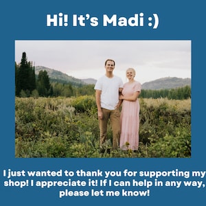 May include: A blue graphic featuring the text Hi! It&rsquo;s Madi :) at the top and a thank you message at the bottom. In the center is a photograph of two people standing in a grassy field with mountains in the background. The person on the left wears a white t-shirt and tan pants, while the person on the right wears a long pink dress.