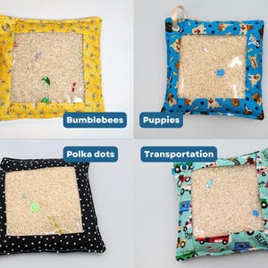 May include: Four square sensory pouches with clear plastic windows filled with rice and small hidden objects. The fabric borders feature patterns of bumblebees, puppies, polka dots, and transportation vehicles, each with a small metal grommet.