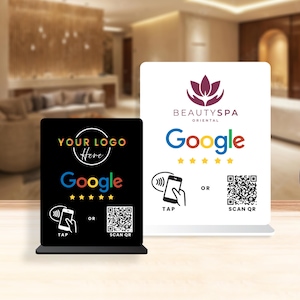 Könnte beinhalten: Zwei Tischschilder mit dem Google-Logo und QR-Codes. Ein Schild ist schwarz mit dem Text "YOUR LOGO Here" und "Google". Das andere Schild ist weiß mit dem Text "BEAUTYSPA ORIENTAL" und "Google". Beide Schilder haben eine Tipp-Option.