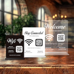 May include: Three signs displaying Wi-Fi details. The signs are black, white, and clear acrylic. Each sign shows the word "Wifi" or "Welcome" and "Stay Connected", a QR code, and network information.