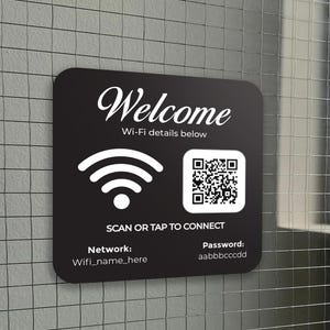 May include: Black square sign with the word "Welcome" in white script. The sign includes Wi-Fi details, a Wi-Fi symbol, a QR code, and instructions to scan or tap to connect. The network name and password are also displayed.