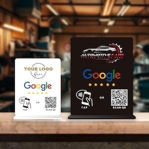 May include: Two table signs, one white and one black, with the Google logo and a QR code. The white sign has the text "YOUR LOGO Here". The black sign has the text "AUTOMOTIVE CARE TACLINE WILL BE HERE".