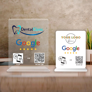 May include: Two clear acrylic signs with the Google logo and QR codes. One sign features the text "Dental Clinic" and "Keep Your Smile." The other sign has "Your Logo Here." Both signs have a "Tap" and "Scan QR" option.