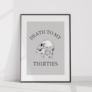 Può includere: Stampa artistica incorniciata con un'illustrazione in bianco e nero di un teschio e una rosa. Il testo sopra il teschio recita "DEATH TO MY" e il testo sottostante recita "THIRTIES". L'opera d'arte è ambientata su uno sfondo grigio chiaro.