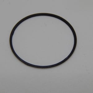 Puede incluir: Una junta t&oacute;rica de goma negra, de forma circular, aislada sobre un fondo blanco. La junta t&oacute;rica es un bucle cerrado, probablemente utilizado para sellar. El di&aacute;metro es de aproximadamente 2,5 cm.