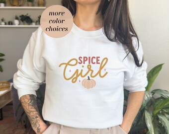 May include: White sweatshirt with the text "Spice Girl" in a yellow and orange font with a small pumpkin graphic.