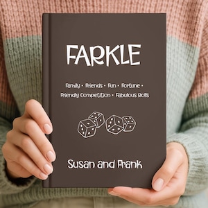 May include: A dark brown hardcover book with the white text FARKLE at the top, followed by the words Family, Friends, Fun, Fortune, Friendly Competition, Fabulous Rolls, a graphic of three dice, and the names Susan and Frank at the bottom.