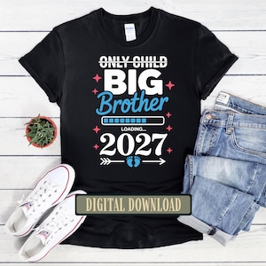 May include: A black t-shirt featuring white and light blue text that reads ONLY CHILD BIG Brother LOADING... 2027, accented with pink star icons, a loading bar graphic, and a pair of blue baby footprints between two horizontal arrows.