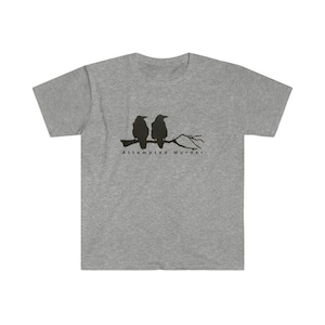 Pode incluir: Uma camiseta cinza com uma silhueta preta de dois corvos empoleirados em um galho. O texto "Attempted Murder" é impresso abaixo dos corvos.