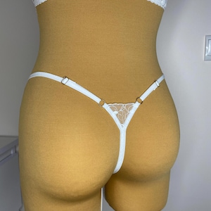 May include: White lace lingerie with delicate straps and a floral design.