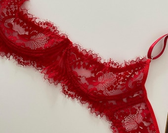 Puede incluir: Sujetador de encaje rojo con delicados patrones florales y bordes festoneados.