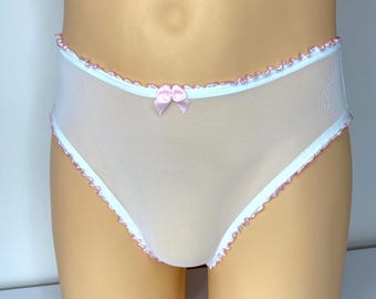 Könnte beinhalten: Weiße Mesh-Unterwäsche mit rosa Besatz und einer kleinen rosa Schleife. Die Kanten sind mit zarten rosa Verzierungen verziert. Die Unterwäsche ist aus leichtem, durchsichtigem Material.