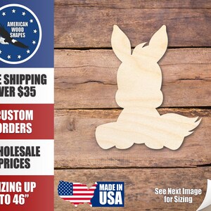 May include: Unfinished wooden cutout of a donkey, suitable for crafts and decorations. The cutout is made of natural wood and has a light brown color. The donkey is sitting with its tail raised and its head tilted to the side.
