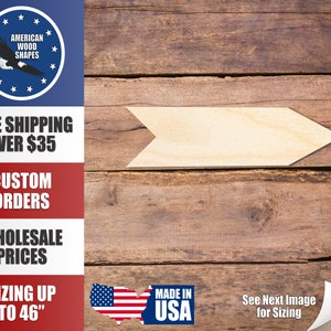 Könnte beinhalten: Eine unfertige Holzpfeilform, bereit zum Bemalen oder Beizen. Der Pfeil befindet sich auf einem Holzmaserungshintergrund. Der Text "Nächstes Bild zur Größenbestimmung ansehen" ist in der unteren rechten Ecke sichtbar.