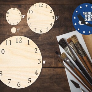 May include: Three unfinished wooden clock faces with numbers 1 through 12. The clock faces are 1 inch, 3 inches, and 8 inches in diameter. The image also includes a blue circle with white stars and a bald eagle, with the text "American Wood Shapes".