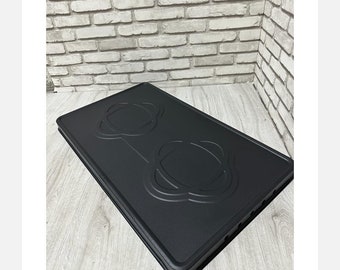 Puede incluir: Protector de encimera de cocina de plástico negro con dos recortes circulares. El protector tiene una superficie texturizada y está diseñado para proteger la encimera de la cocina de arañazos y derrames.