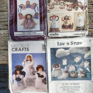 May include: Four sewing pattern packets for fabric angel ornaments and decorations. The packets feature illustrations of finished angel dolls with various hair colors, fabric dresses, and wings. Text includes Hickory Stick & Co., Crafts Magazine, McCall's Crafts, and Luv 'n Stuff Lil' Bits of Heaven.