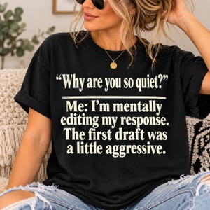 May include: A black short-sleeved t-shirt featuring white text that reads: "Why are you so quiet?" followed by "Me: I'm mentally editing my response. The first draft was a little aggressive." The shirt has a crew neckline and a relaxed fit.