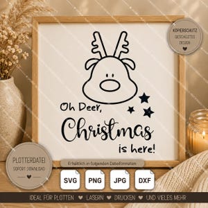 May include: A square wooden frame containing a white print with a black line drawing of a reindeer head, three small stars, and the text "Oh Deer, Christmas is here!" in a mix of sans-serif and cursive fonts, presented as a digital design file.