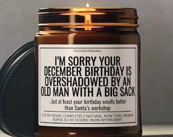 May include: A brown glass candle jar with a black label that reads "I'm sorry your December birthday is overshadowed by an old man with a big sack...but at least your birthday smells better than Santa's workshop." The candle is 9 oz of vegan, completely natural, non-toxic aromas and burns 50-60 hours.