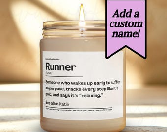 May include: A lit candle in a clear glass jar with a white label. The label reads "Runner" with a definition and the text "Add a custom name!" on a pink banner. The candle is on a light-colored surface.