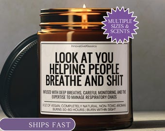 May include: A lit brown glass candle jar with a black lid. The label reads "LOOK AT YOU HELPING PEOPLE BREATHE AND SHIT." The candle is advertised as vegan, non-toxic, and with a burn time of 50-60 hours. A purple starburst indicates multiple sizes and scents.