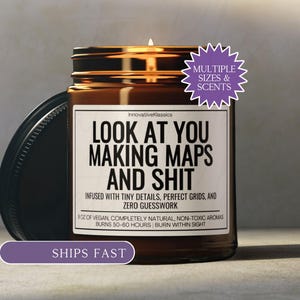 May include: A white ceramic mug with a black handle and the text "But First, Coffee" in a bold, black font. The mug is set against a blurred background, suggesting a cozy setting.