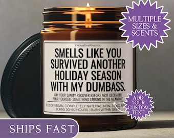 May include: A brown glass candle jar with a black lid, featuring a white label with the text "Smells Like You Survived Another Holiday Season With My Dumbass." The candle is 9 oz and burns for 50-60 hours.