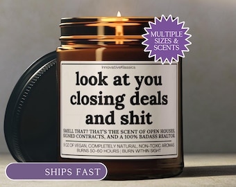 May include: A lit brown glass jar candle with a black lid. The candle has a white label with the text "look at you closing deals and shit". The candle is labeled "InnovativeKlassics" and has a purple sticker that says "Multiple Sizes & Scents".