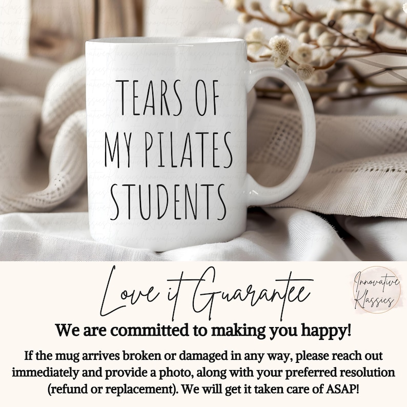 May include: White ceramic coffee mug with black text that reads "Tears of My Pilates Students". The mug is sitting on a white and beige fabric surface.