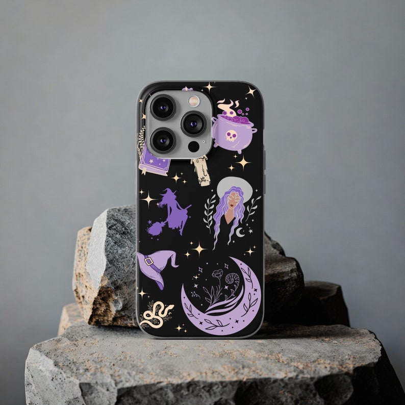 May include: A black phone case with a purple and white witchy design. The design features a witch on a broomstick, a cauldron, a crescent moon, and stars.