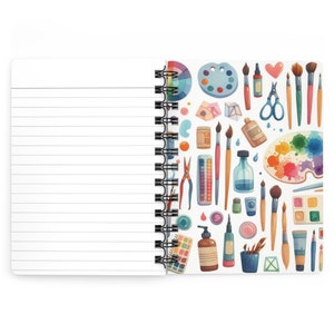 Puede incluir: Un cuaderno blanco de espiral con una cubierta colorida que presenta varios art&iacute;culos de arte, incluidos pinceles, paletas de pintura y tubos de pintura. La cubierta est&aacute; decorada con un efecto acuarela.
