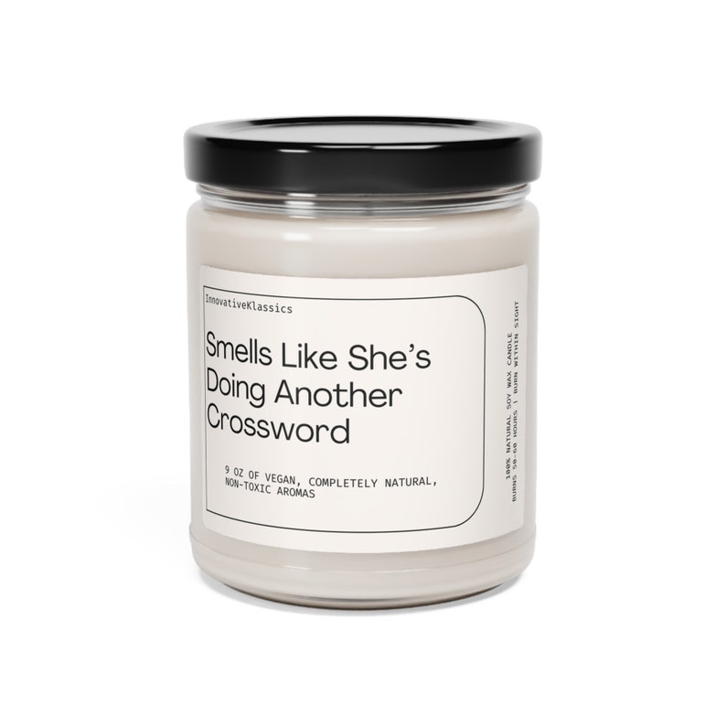 K&ouml;nnte beinhalten: Eine 9 oz Sojawachskerze in einem klaren Glasgef&auml;&szlig; mit schwarzem Deckel. Das wei&szlig;e Etikett tr&auml;gt den Text: InnovativeKlassics, Smells Like She's Doing Another Crossword, 9 OZ OF VEGAN, COMPLETELY NATURAL, NON-TOXIC AROMAS, 100% NATURAL SOY WAX CANDLE.