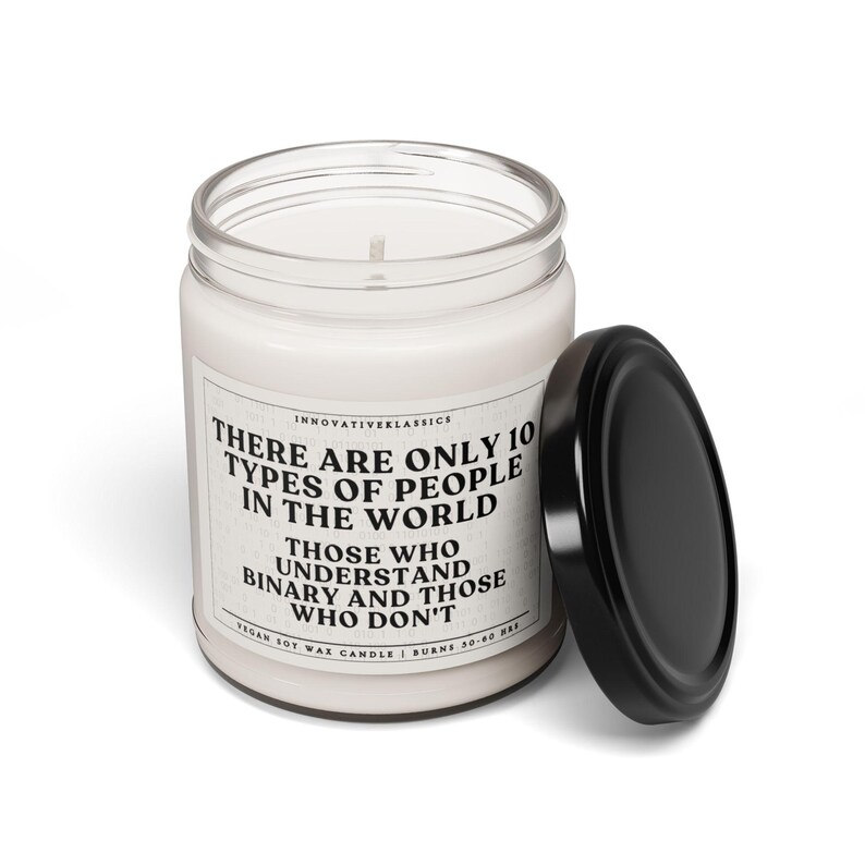 May include: A white candle jar with a black lid. The jar has a white label with black text that reads "There are only 10 types of people in the world. Those who understand binary and those who don't. Vegan soy wax candle | Burns 50-60 hrs."