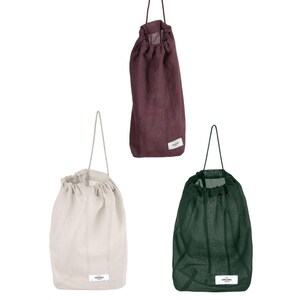 May include: Three reusable shopping bags made of natural fabric. The bags are in burgundy, beige, and dark green. Each bag has a drawstring closure and a small label with the word "organic" printed on it.