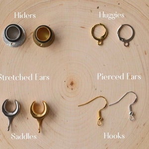 May include: Assortment of earring findings for stretched and pierced ears.  The findings are made of silver and gold metal.  The findings include:  hiders, huggies, saddles, and hooks.