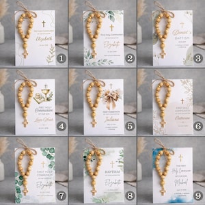 May include: A collection of nine rectangular cards featuring wooden bead rosaries with gold crosses tied with twine. Each card displays religious text, dates, and names like Elizabeth, Daniel, Liam Noah, Juliana, Catherine, and Michael with floral motifs.