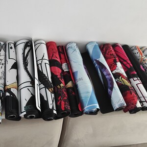 Puede incluir: Una colecci&oacute;n de 15 alfombrillas de rat&oacute;n enrolladas con varios dise&ntilde;os coloridos de c&oacute;mics. Las alfombrillas de rat&oacute;n est&aacute;n dispuestas en un sof&aacute; marr&oacute;n claro.