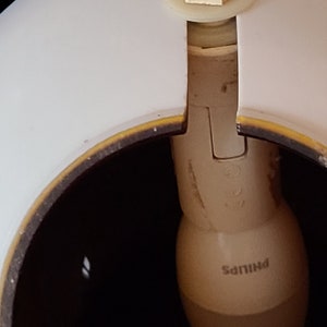 K&ouml;nnte beinhalten: Ein wei&szlig;er Lampenschirm mit braunem Rand und einer Philips-Gl&uuml;hbirne im Inneren.