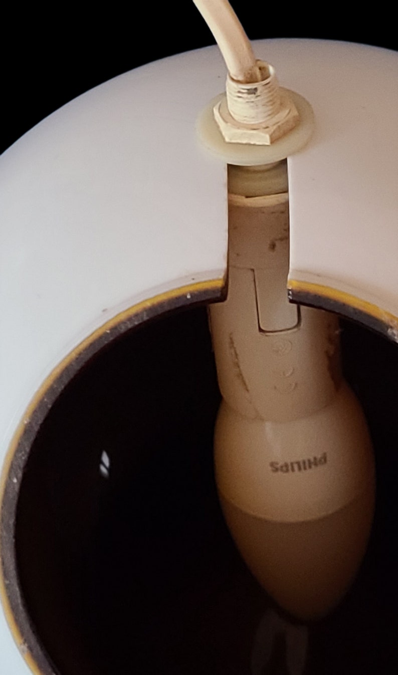 K&ouml;nnte beinhalten: Ein wei&szlig;er Lampenschirm mit braunem Rand und einer Philips-Gl&uuml;hbirne im Inneren.